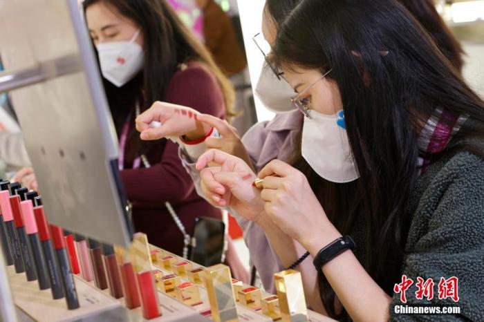 圖為女生正在體驗(yàn)口紅產(chǎn)品。 殷立勤 攝